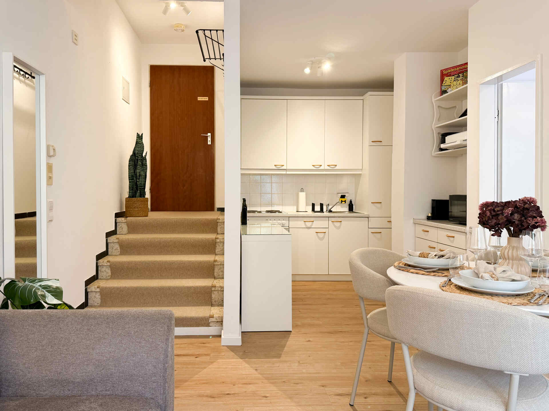 Blick vom Wohnzimmer zur Kueche mit Treppe