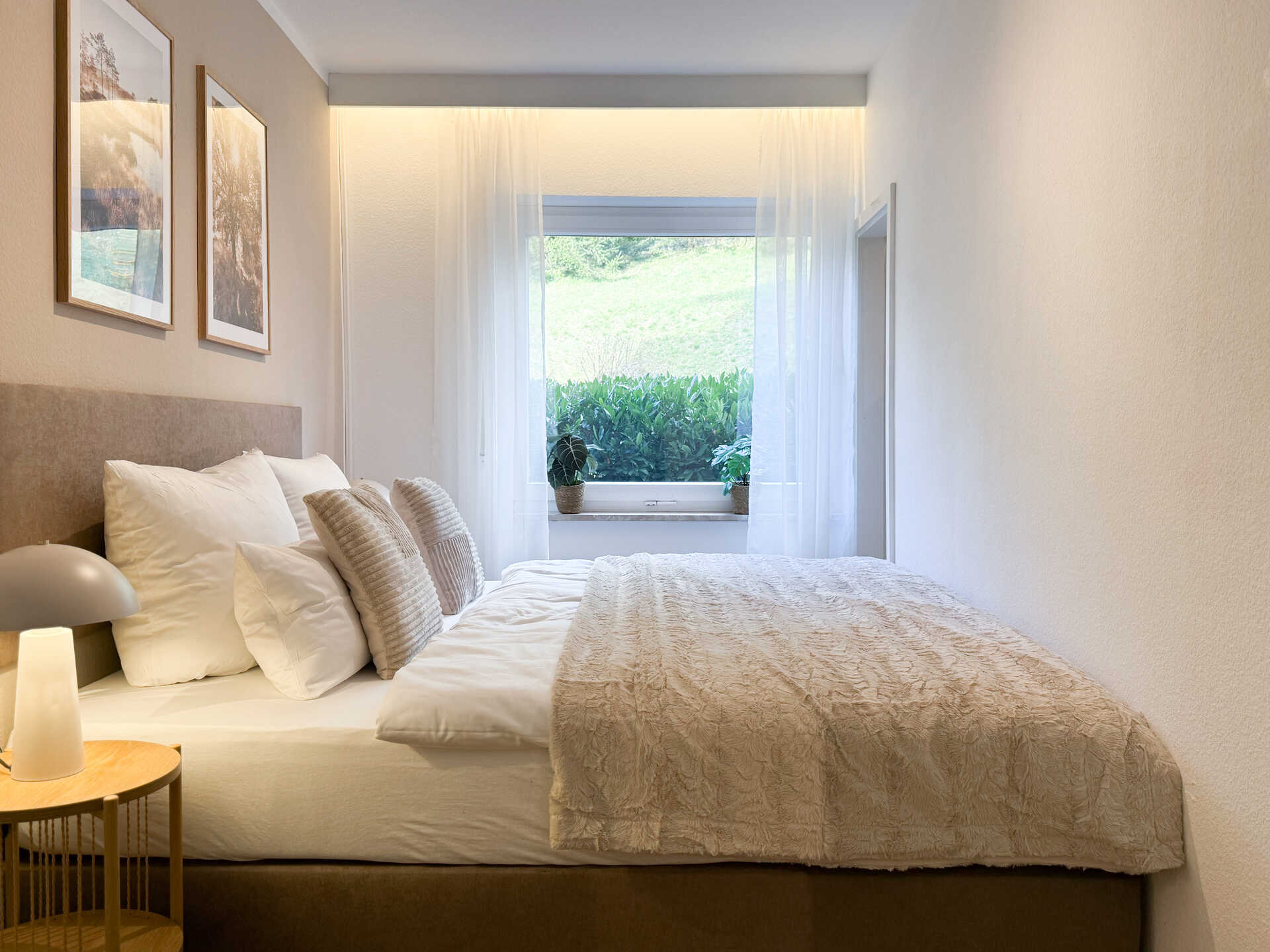 Doppelbett mit Kissen und Fensterblick