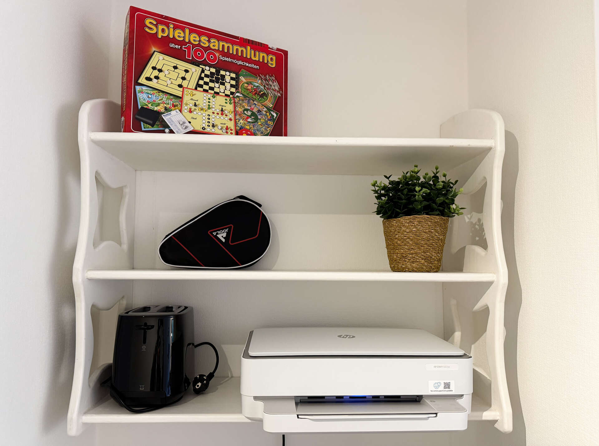Regal mit Spielesammlung und Drucker