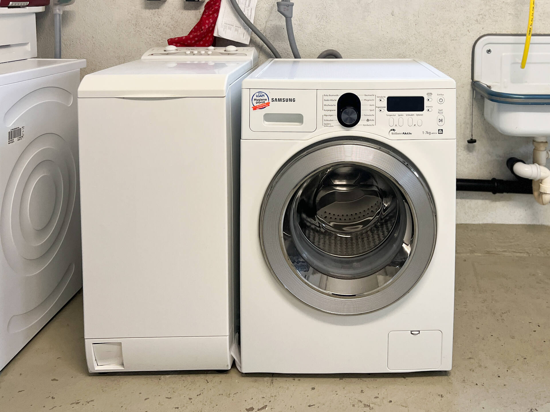 Waschmaschine und Trockner im Waschraum