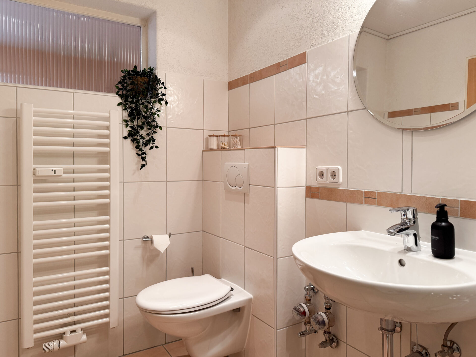 Waschbecken mit Spiegel und Handtuchheizung