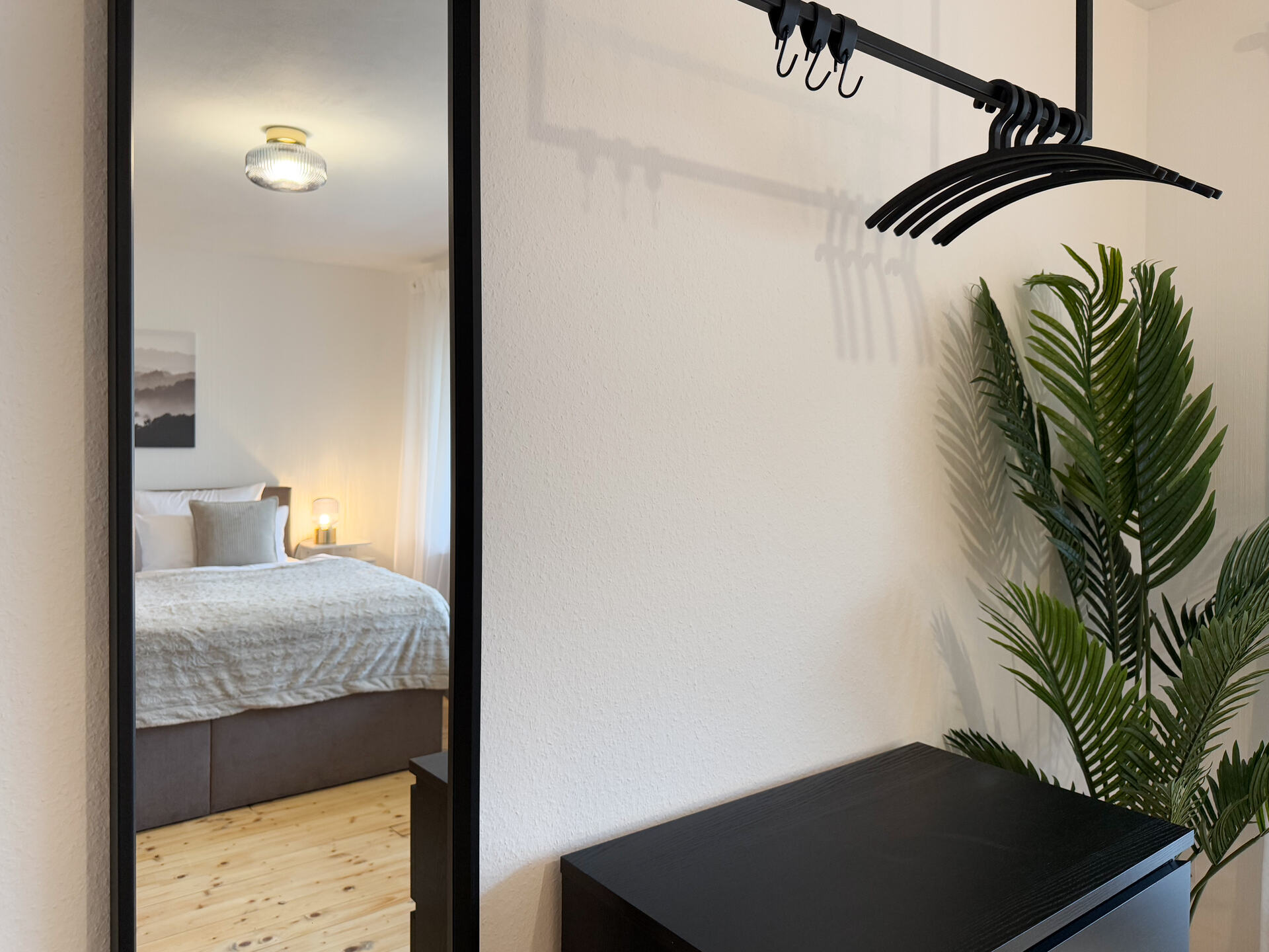 Spiegelblick auf Bett und Kleiderstange