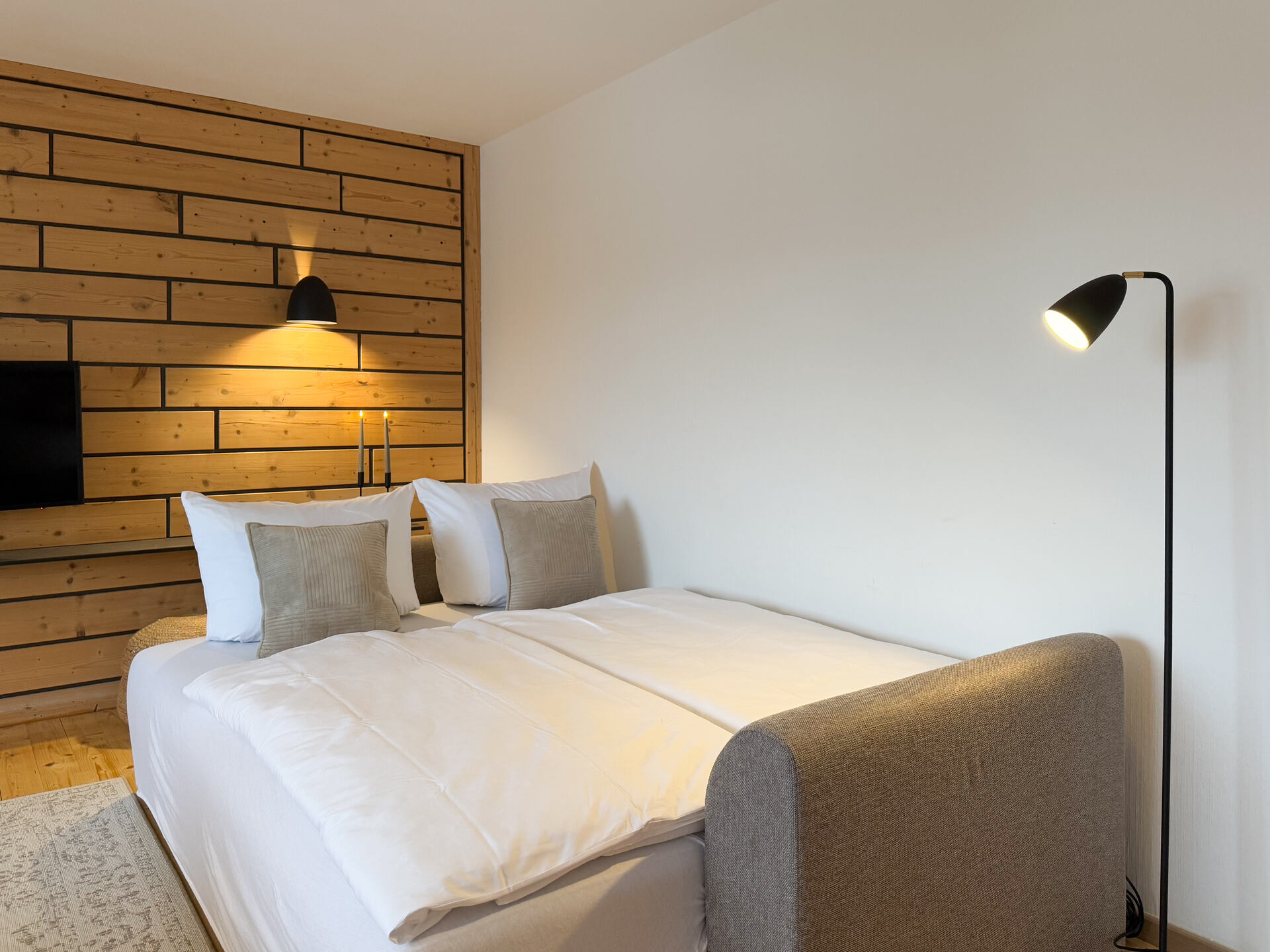 Schlafsofa mit Holzrueckwand und Stehlampe