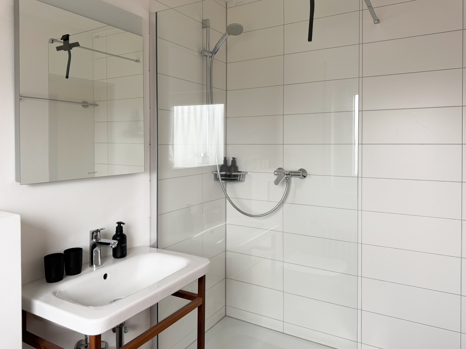 Moderne Dusche mit weisser Fliesenwand