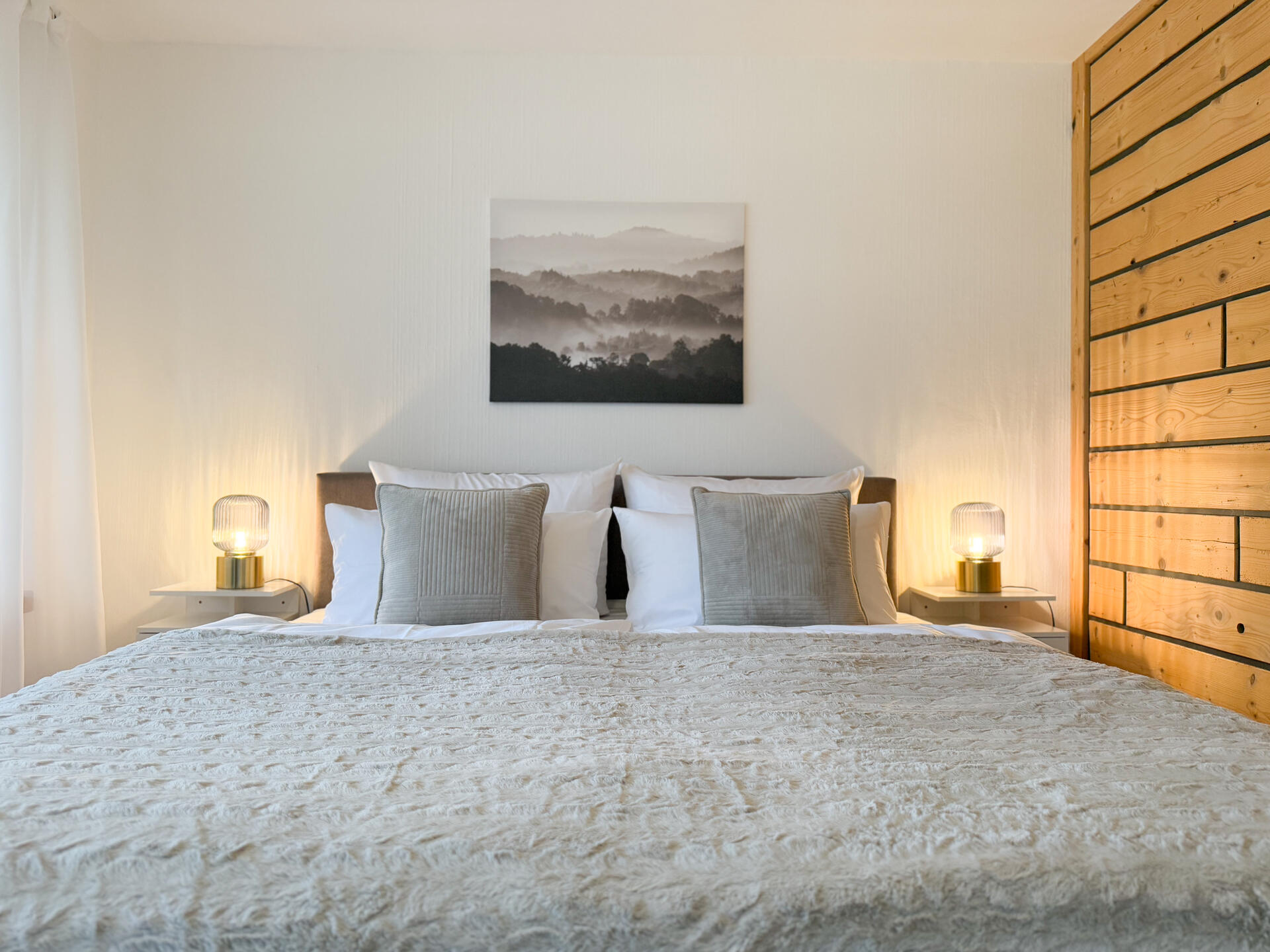 Doppelbett mit Holzdetails und Wandbild