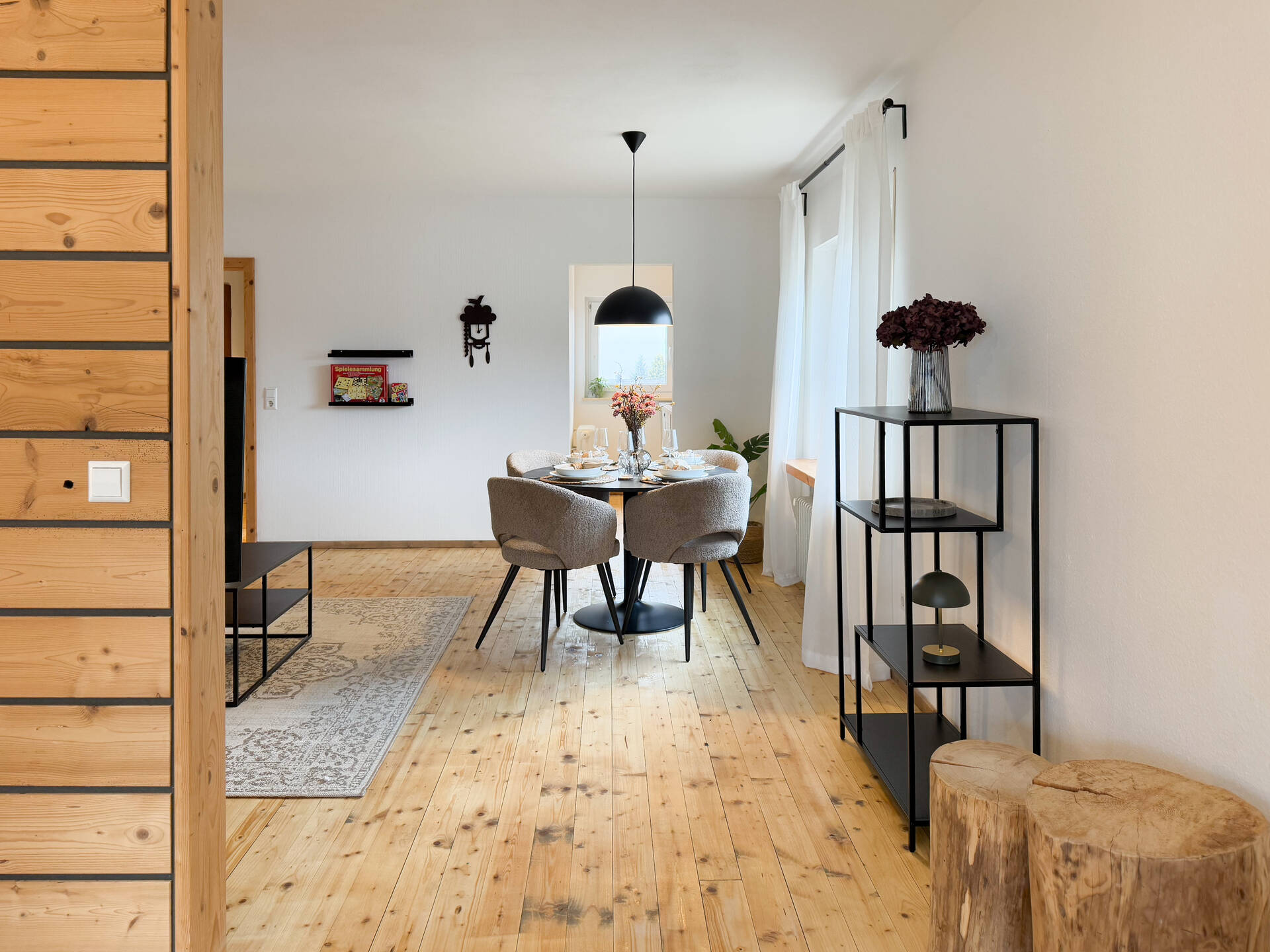 Wohnbereich mit Esstisch und Holzwand