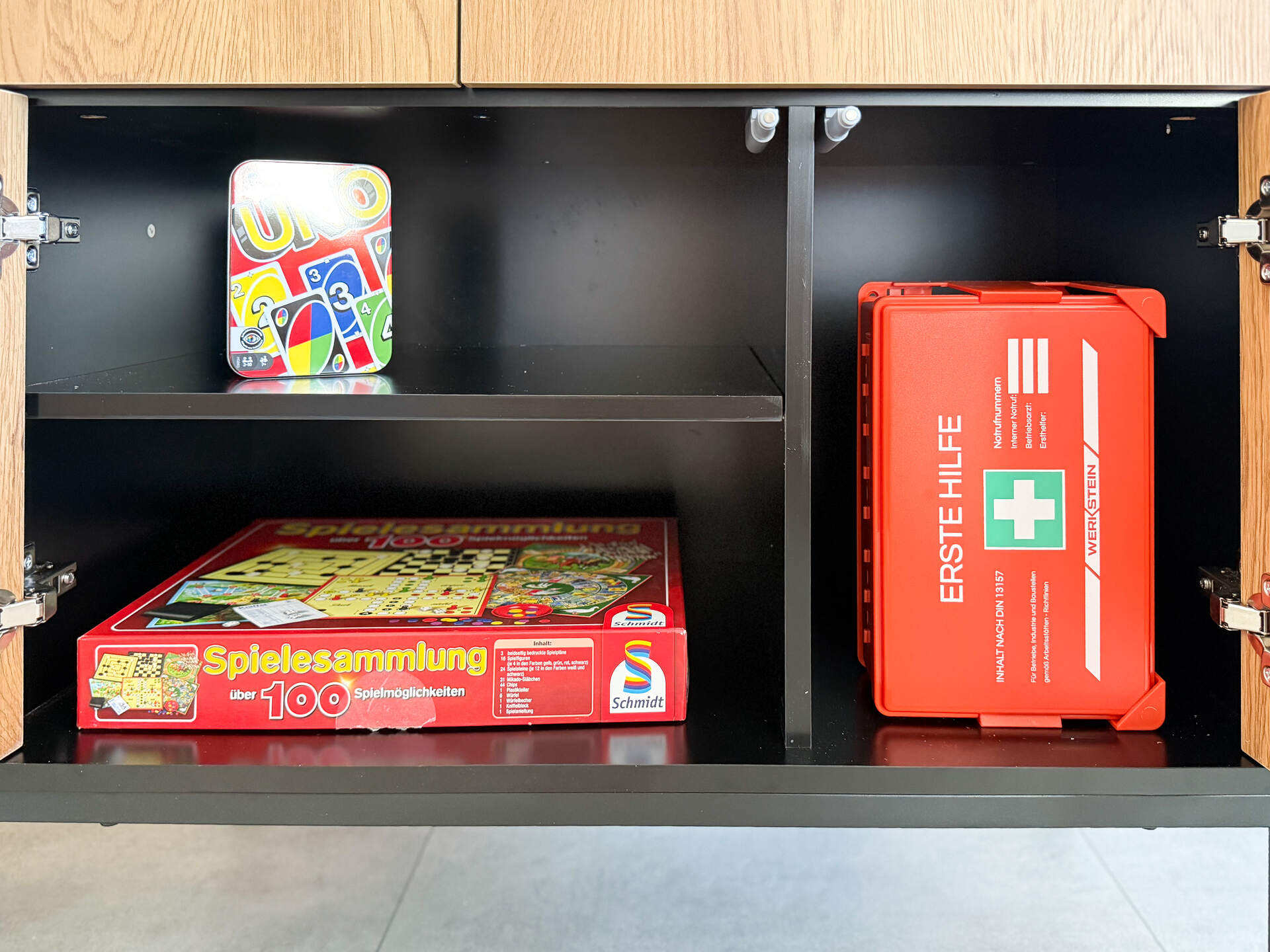 Spielesammlung und Erste-Hilfe-Kasten im Schrank