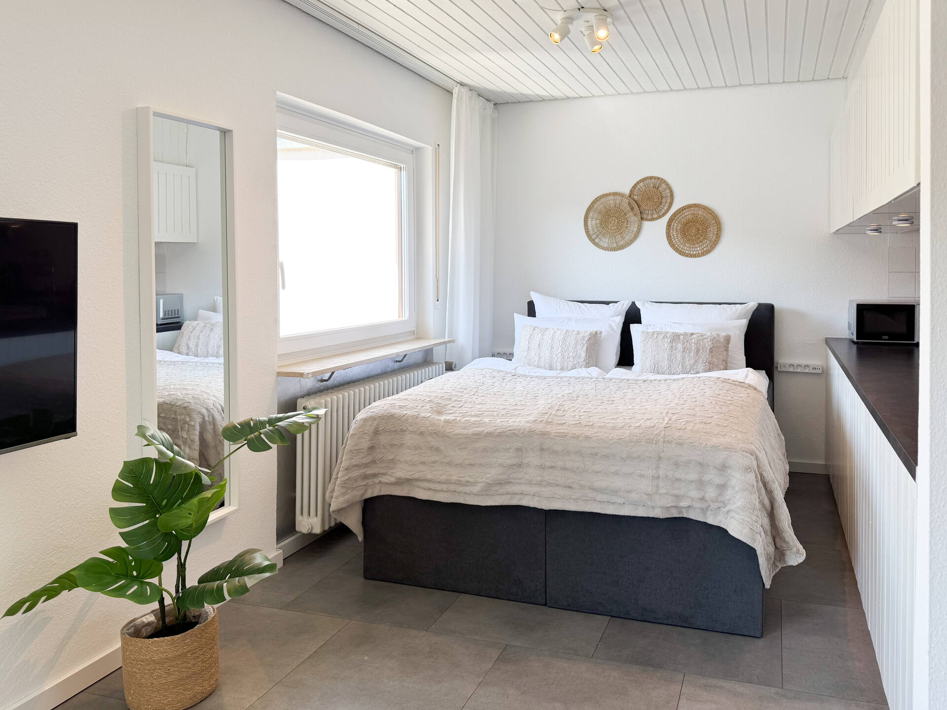 Schlafbereich mit Spiegel und Dekowand