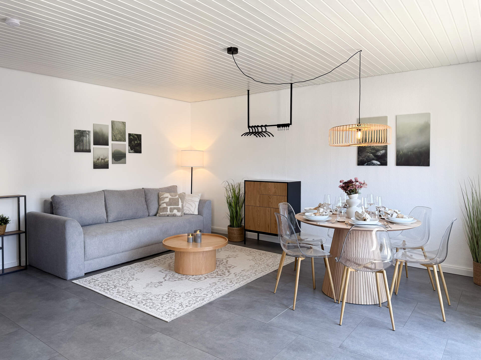 Wohnzimmer mit Sofa, Esstisch und Kleiderstange