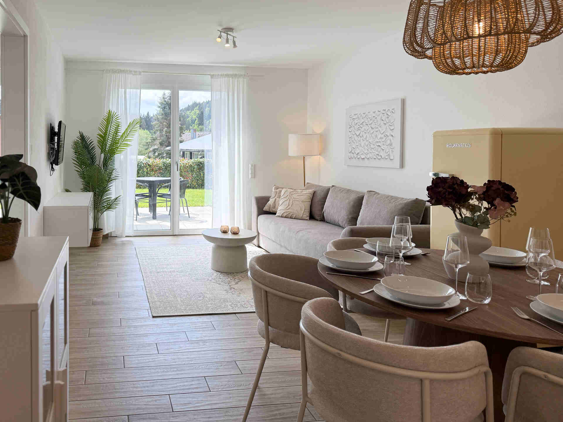 Blick ins Wohnzimmer mit grossem Esstisch und Gartenterrasse