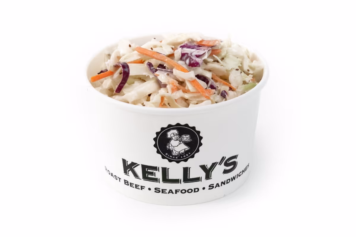 A paper container labeled "Kelly's" filled with coleslaw, featuring shredded cabbage and carrots.