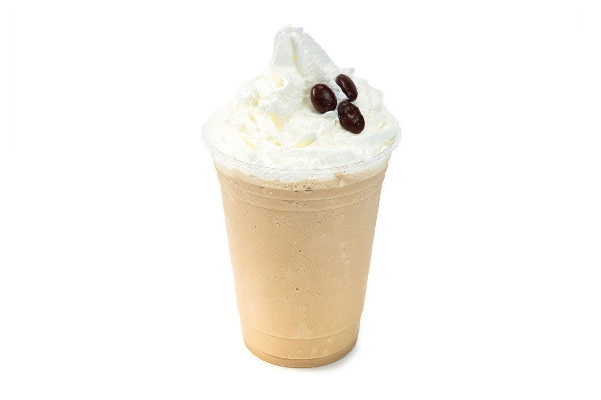 Iced coffee drink in a clear cup, topped with whipped cream and three coffee beans, on a white background.