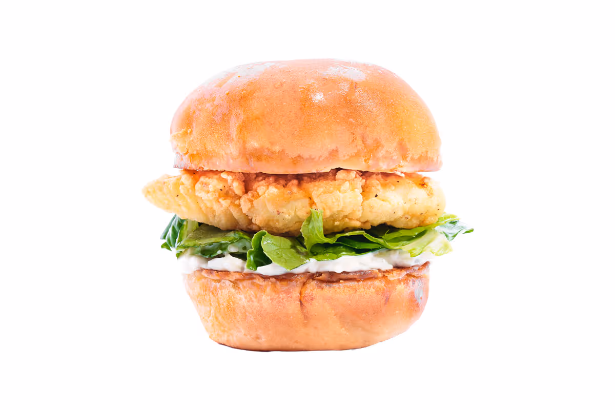 Fried chicken sandwich with lettuce and mayonnaise on a bun, photographed against a white background.