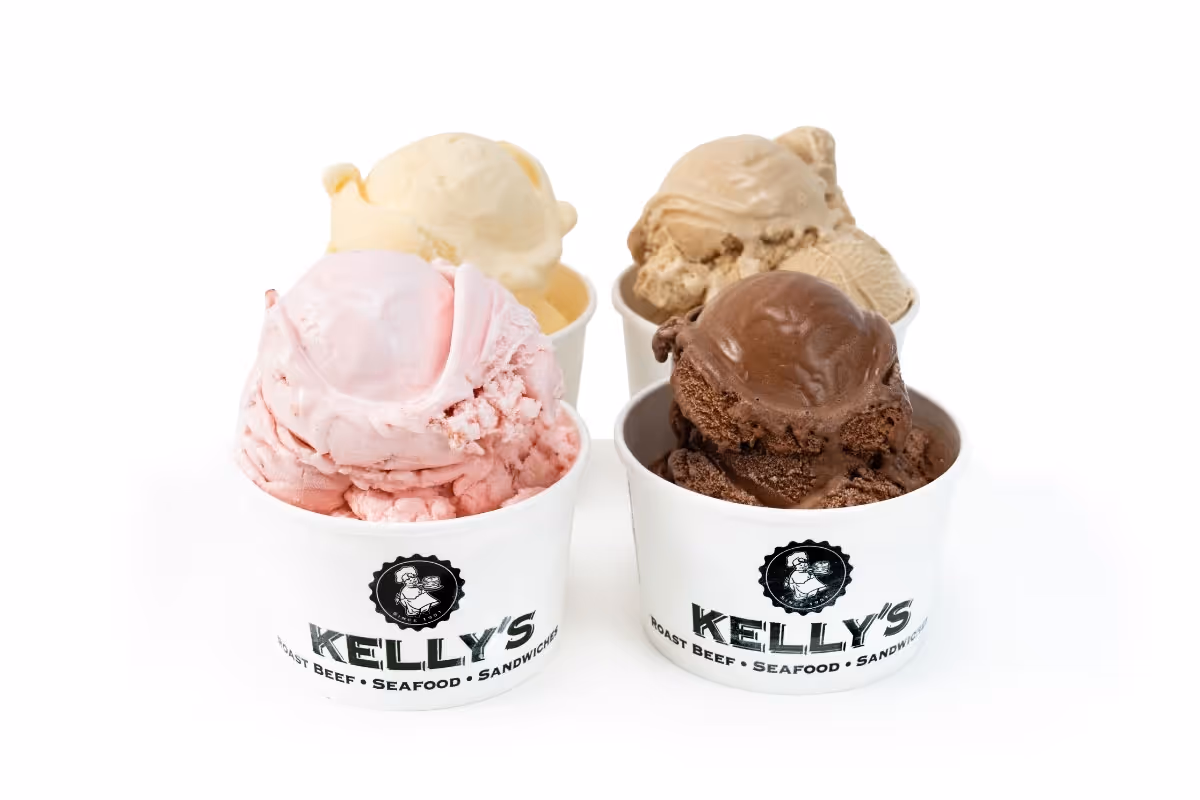 Four cups of ice cream in different flavors—pink, chocolate, tan, and vanilla—are arranged on a white surface.