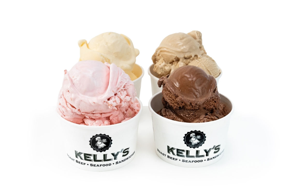 Four cups of ice cream in different flavors—pink, chocolate, tan, and vanilla—are arranged on a white surface.