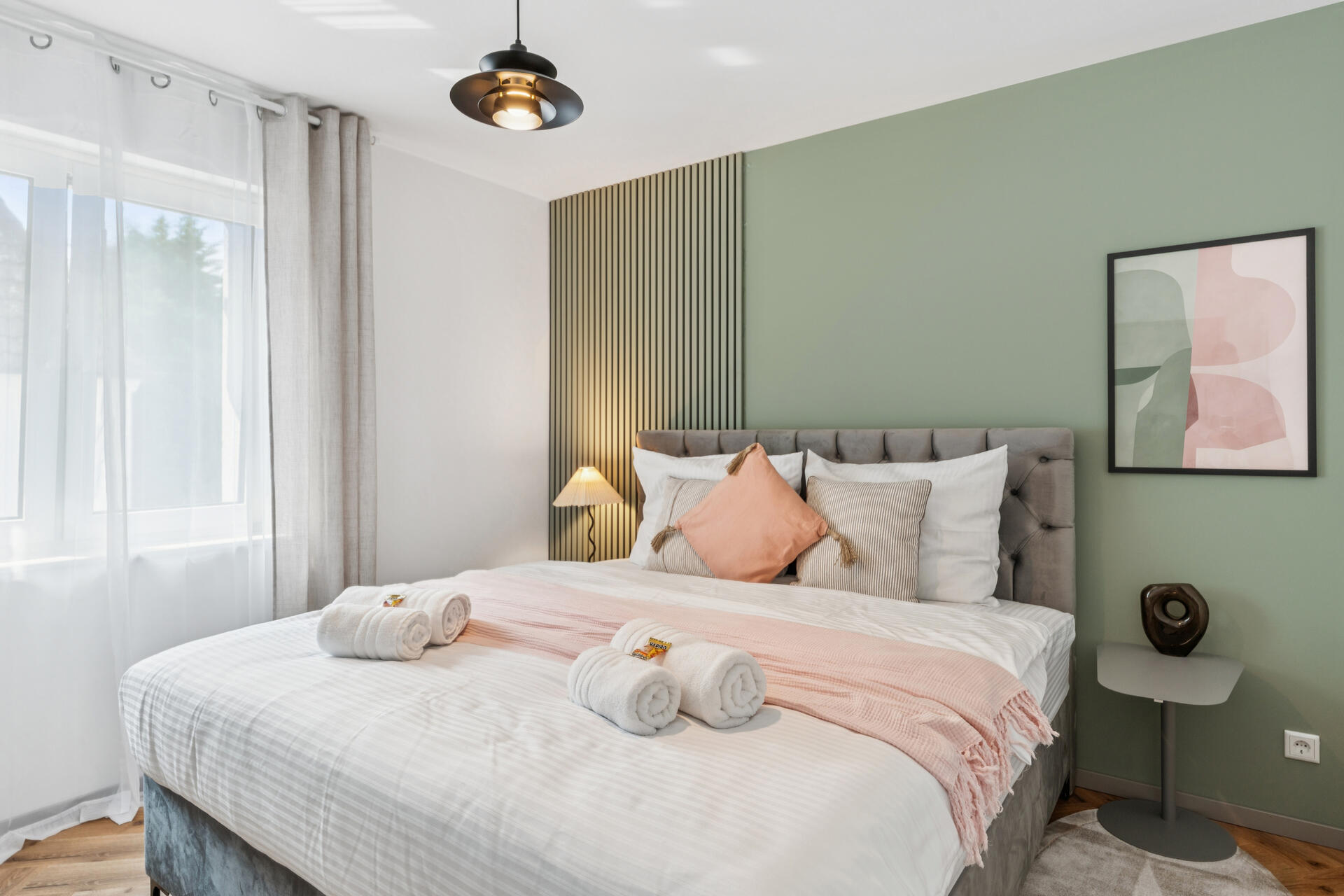 Moderne Kingsize-Bett mit Kissen dekoriert und Wandbildern