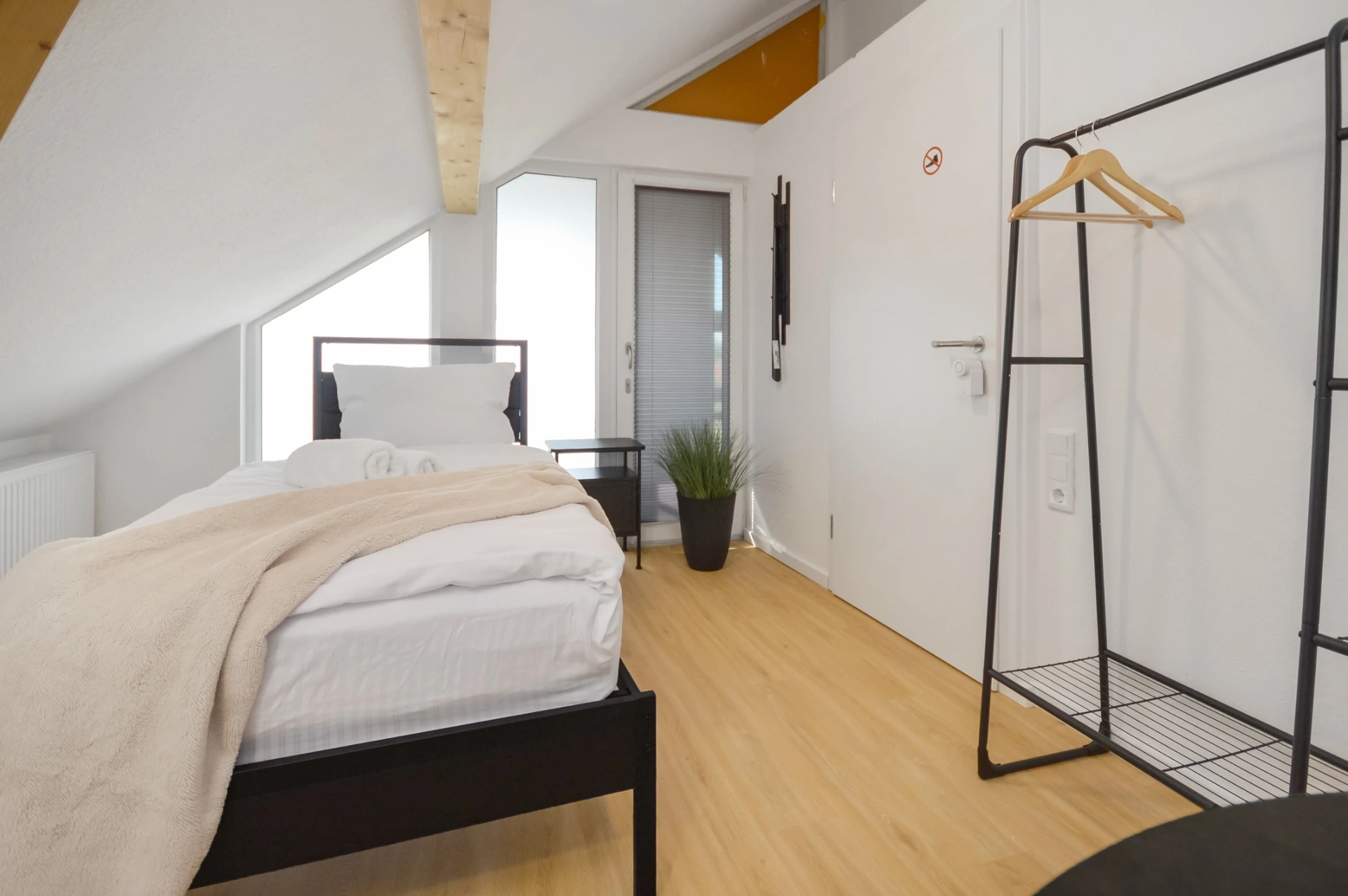 Helles Ein-/Zweibettzimmer im Sandstraße Apartment in Detmold mit modernem Einzelbett und stilvoller Einrichtung.