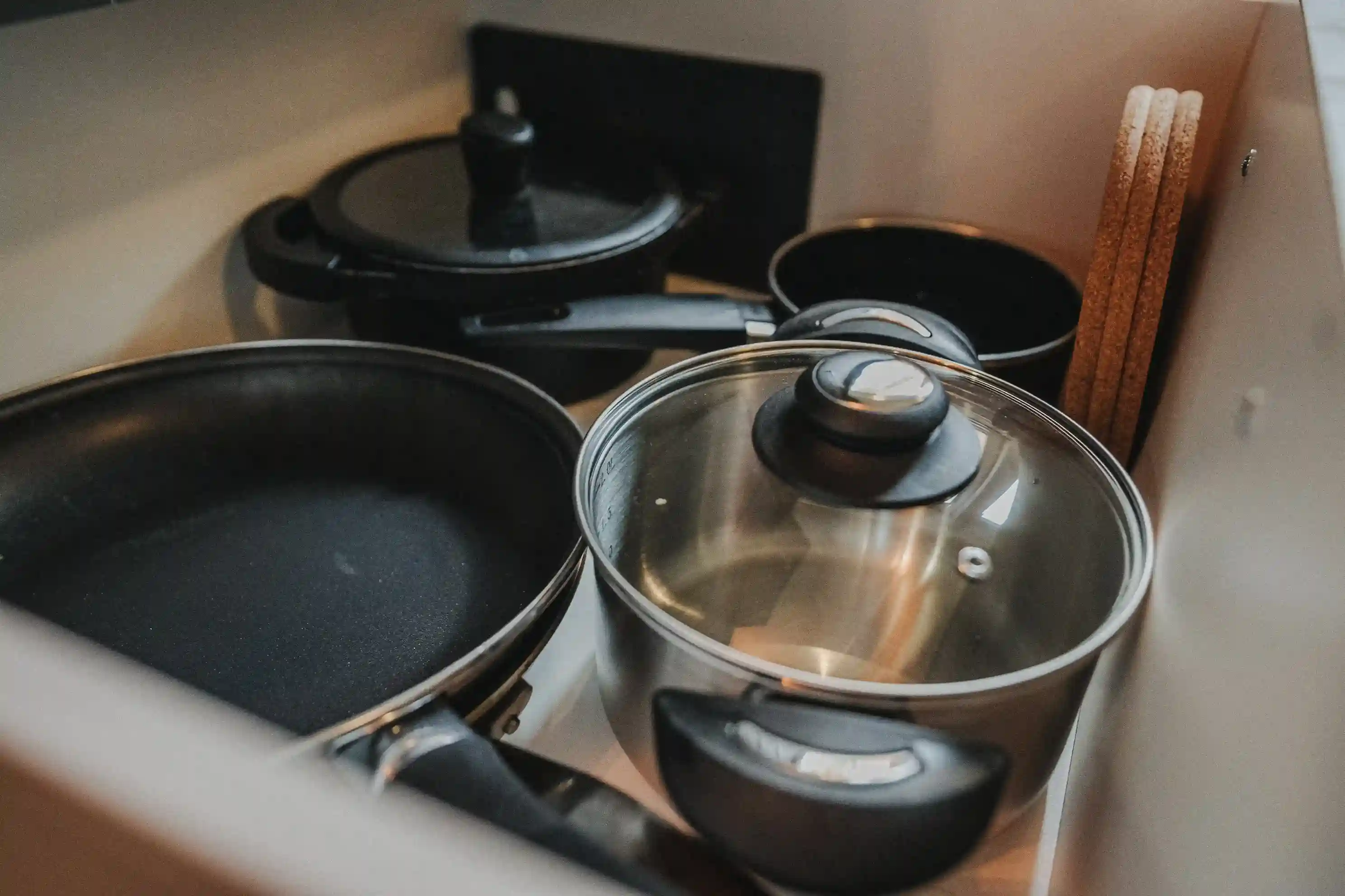 Schublade mit Töpfen, Pfannen und Untersetzern