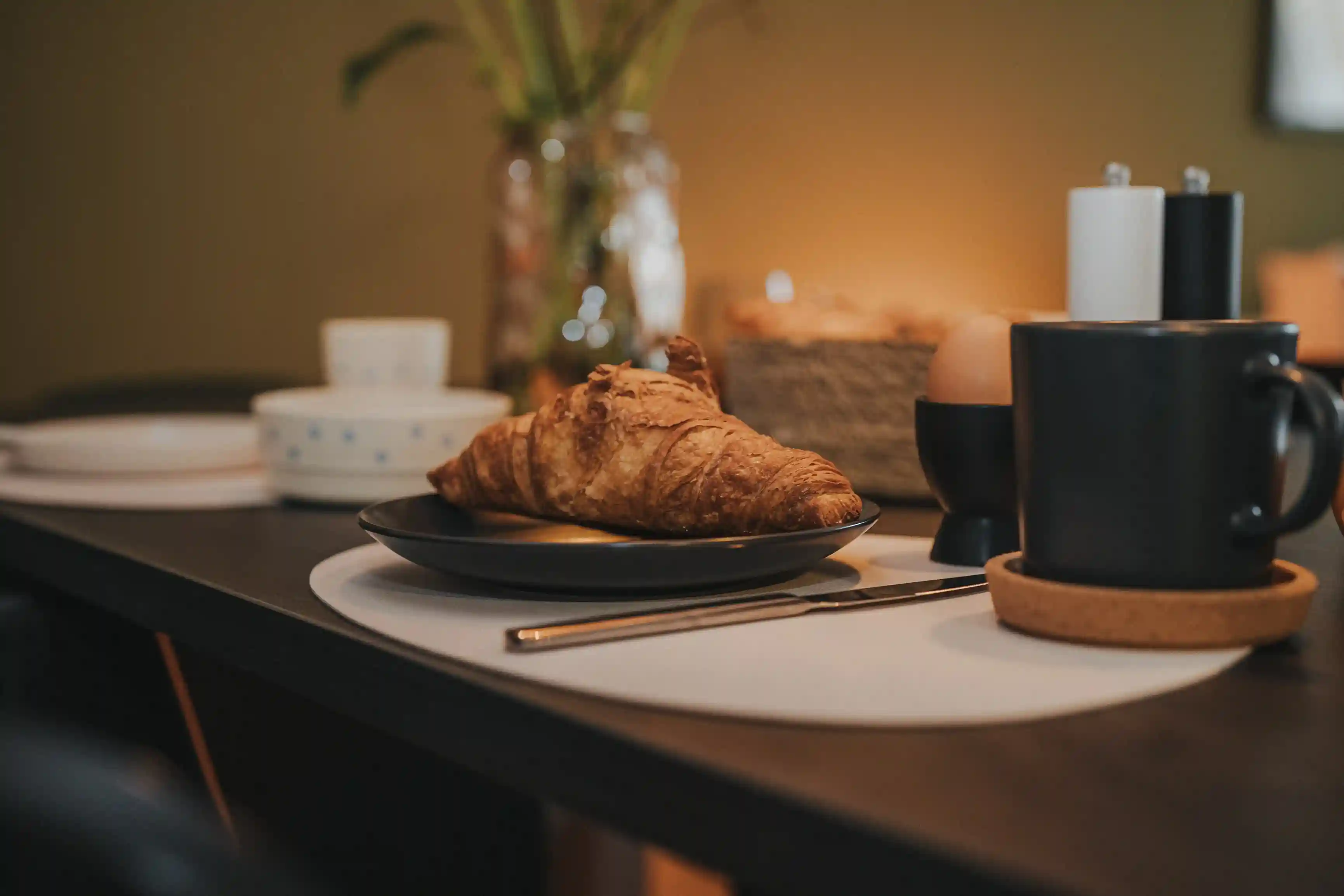 Nahaufnahme Frühstückstisch mit Croissant und Kaffee