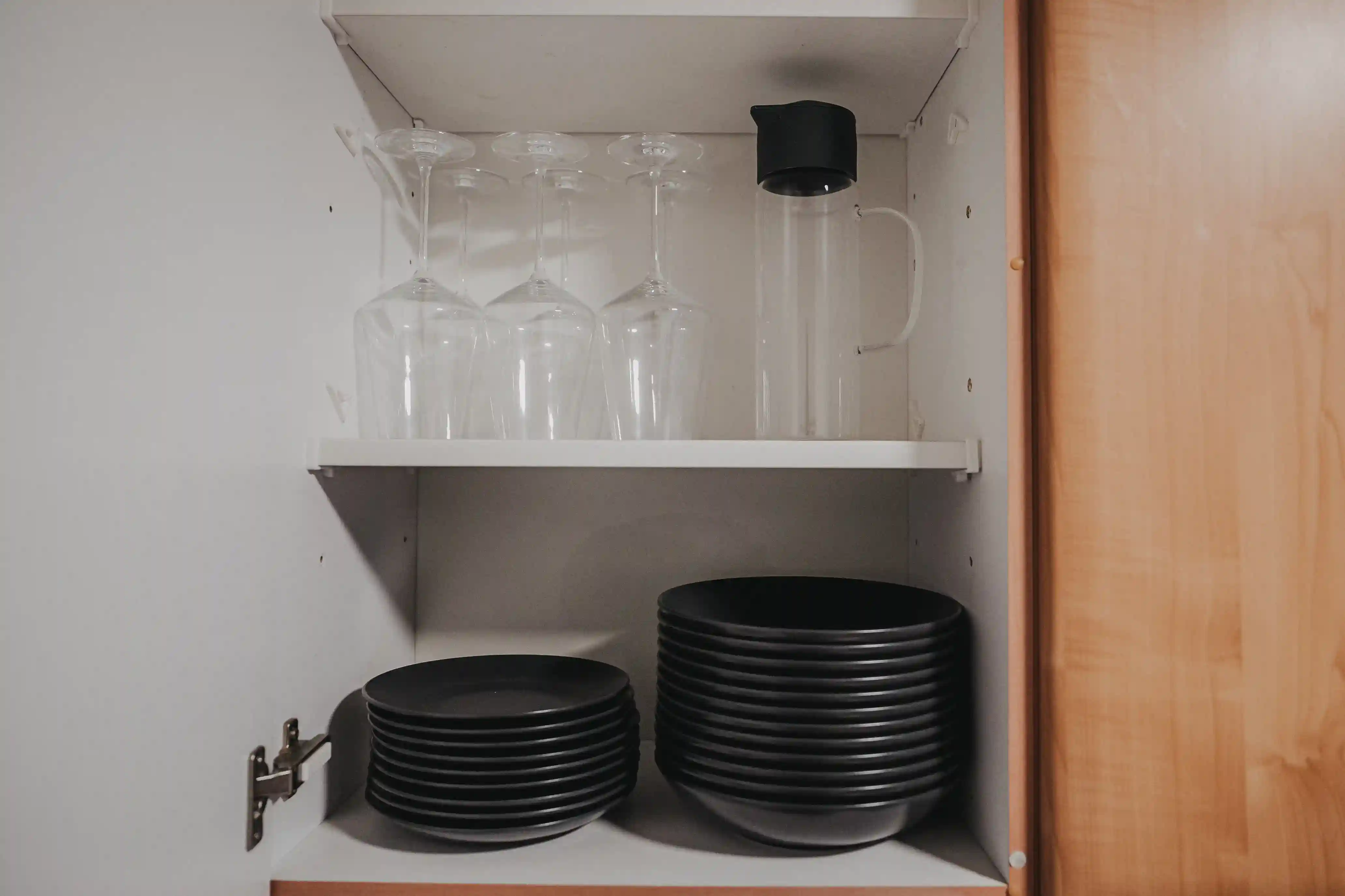 Schwarze Teller und Gläser im Küchenschrank