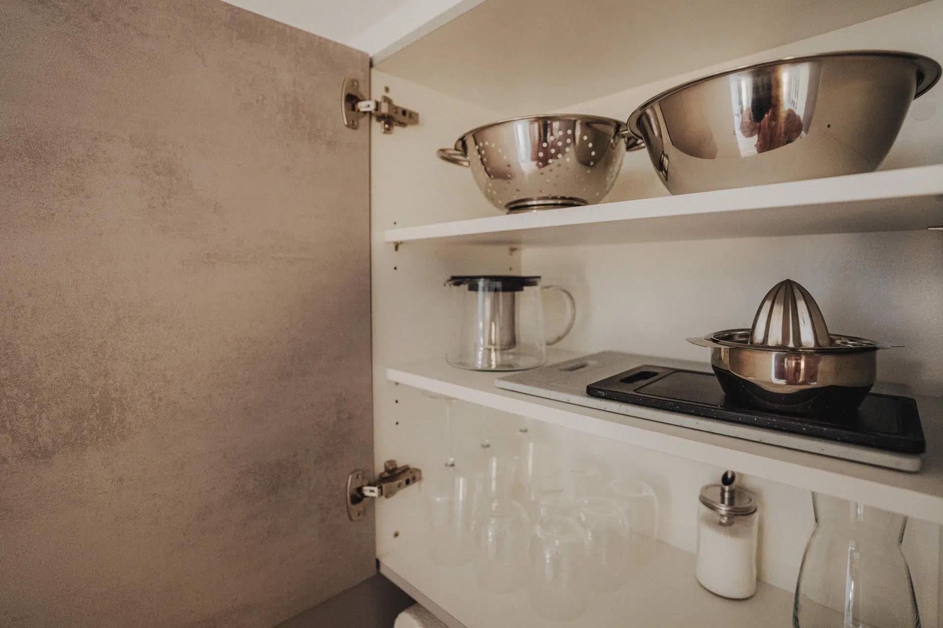 Schrank mit Schüsseln, Gläsern und Zitruspresse