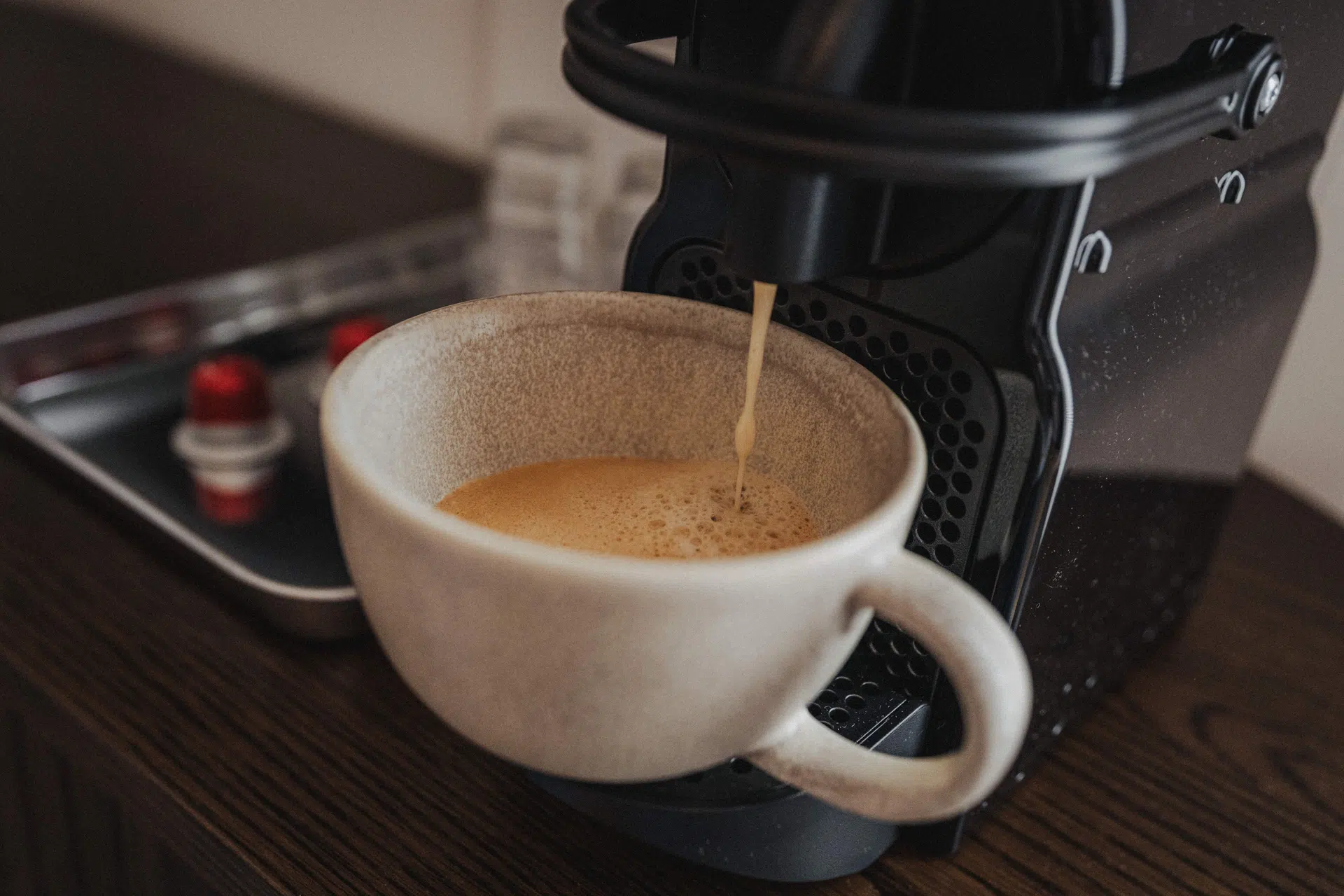 Frisch gebrühter Kaffee läuft in eine helle Tasse