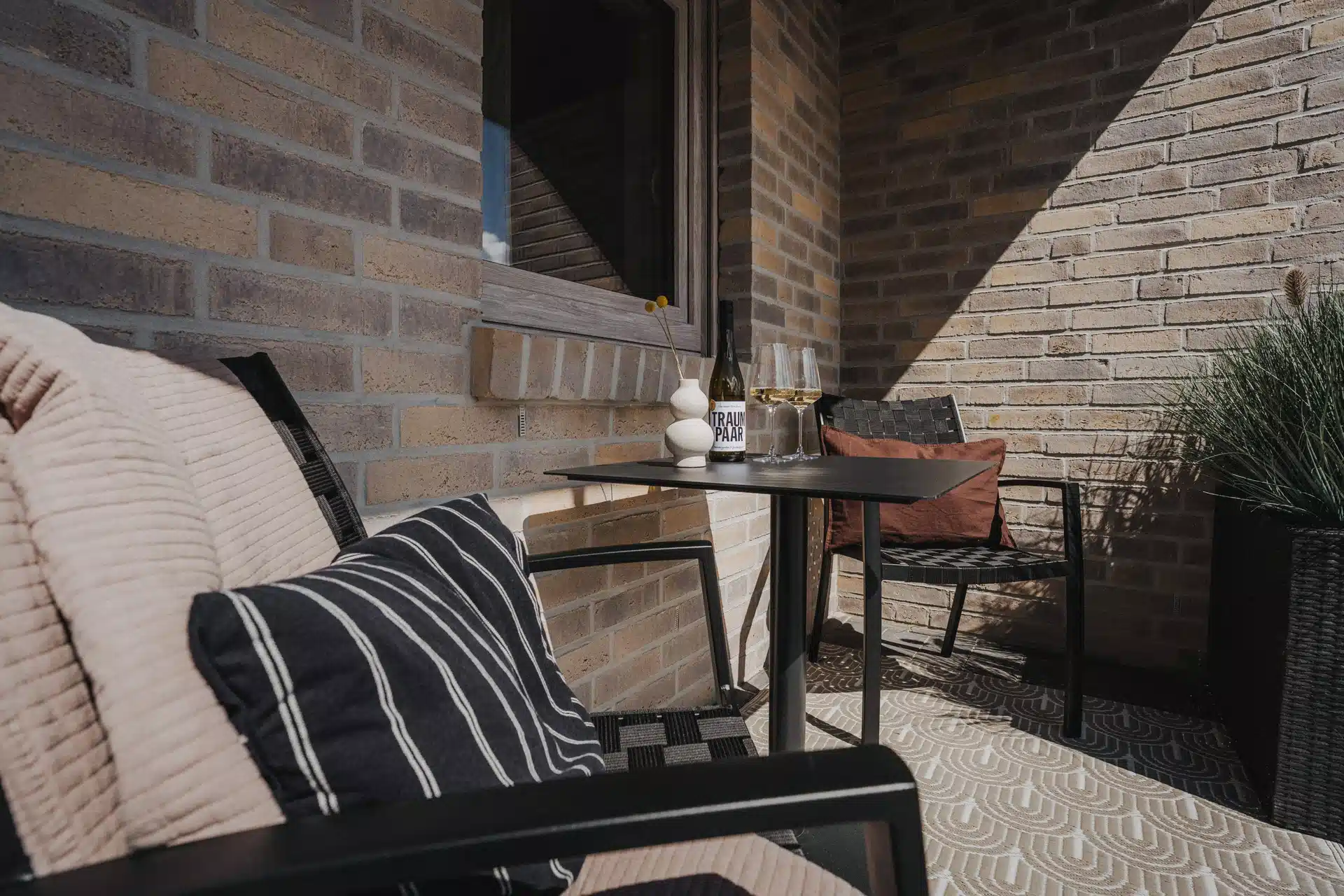 Sitzecke auf der Terrasse mit Kissen, Teppich und Pflanzen