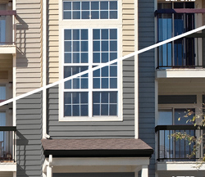 Close-up of a modern building facade with large grid-patterned windows and balconies.