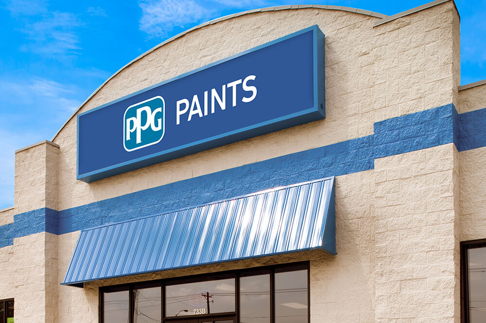 Exterior of a PPG Paints store with a blue sign and metal awning under a partly cloudy sky.