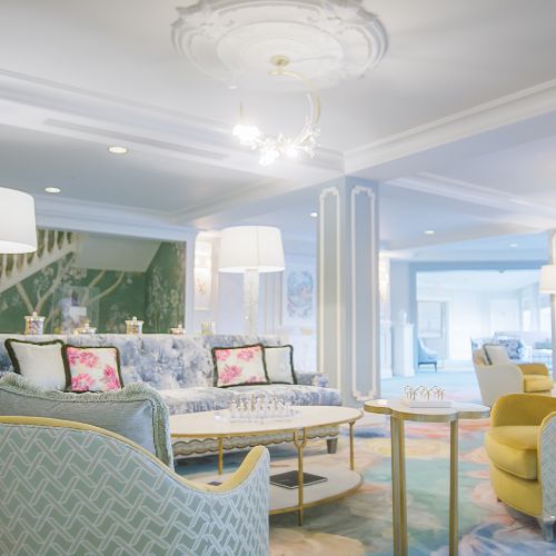 Elegantly furnished lounge with plush pastel sofas, floral cushions, and soft ambient lighting.