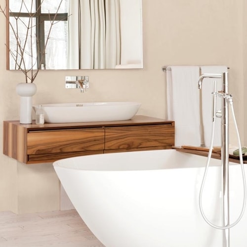 Modern bathroom with a white freestanding bathtub, wooden floating vanity with vessel sink, and a wall-mounted mirror.