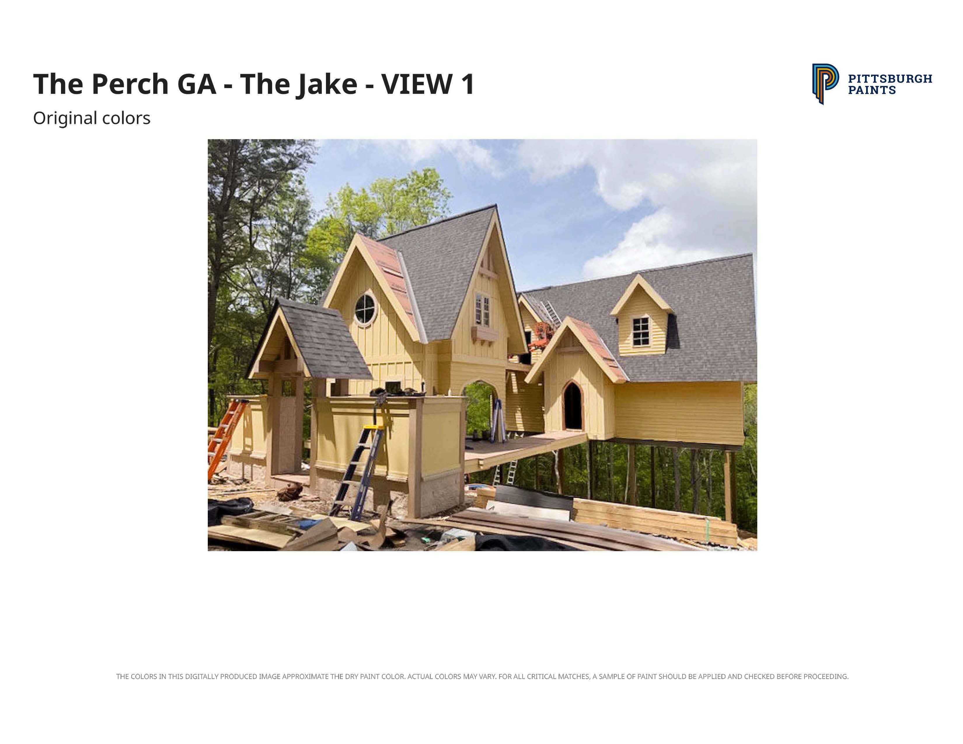 Yellow house under construction with steep gray roofs surrounded by trees on a clear day.
