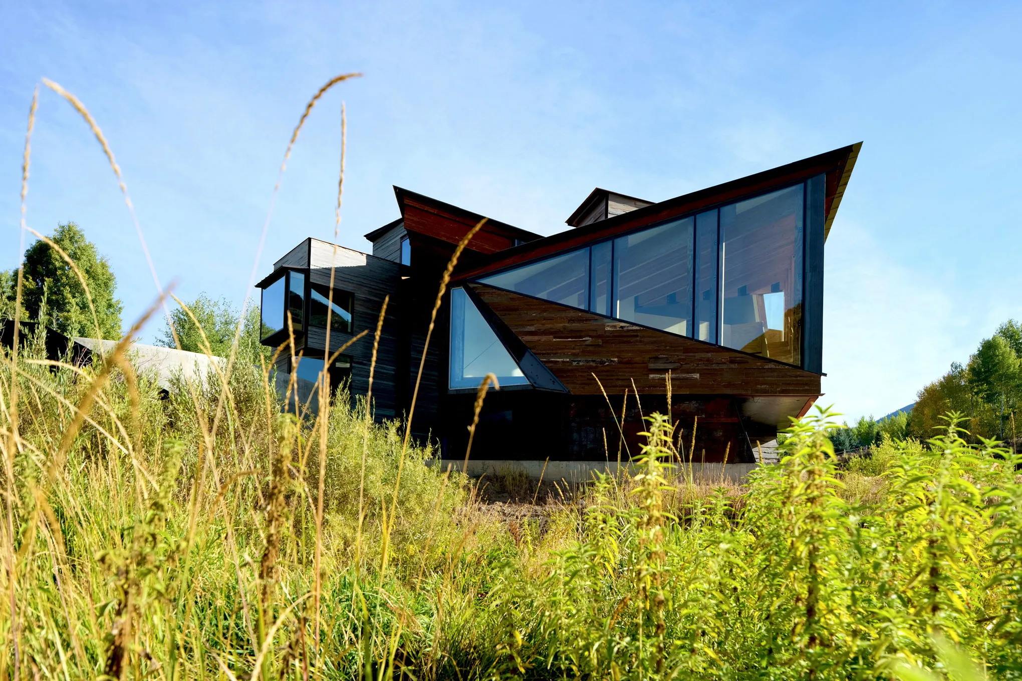 Modern angular home with expansive glass walls and natural wood siding, designed by architect Susan Desko in Idaho’s International Dark Sky Preserve.