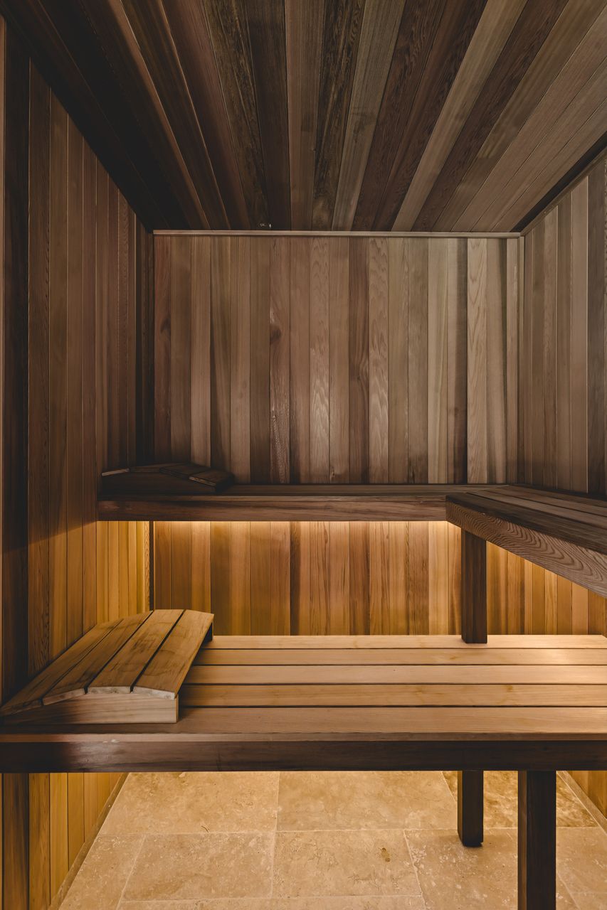 Handcrafted cedar bench seating and backrest in a custom sauna