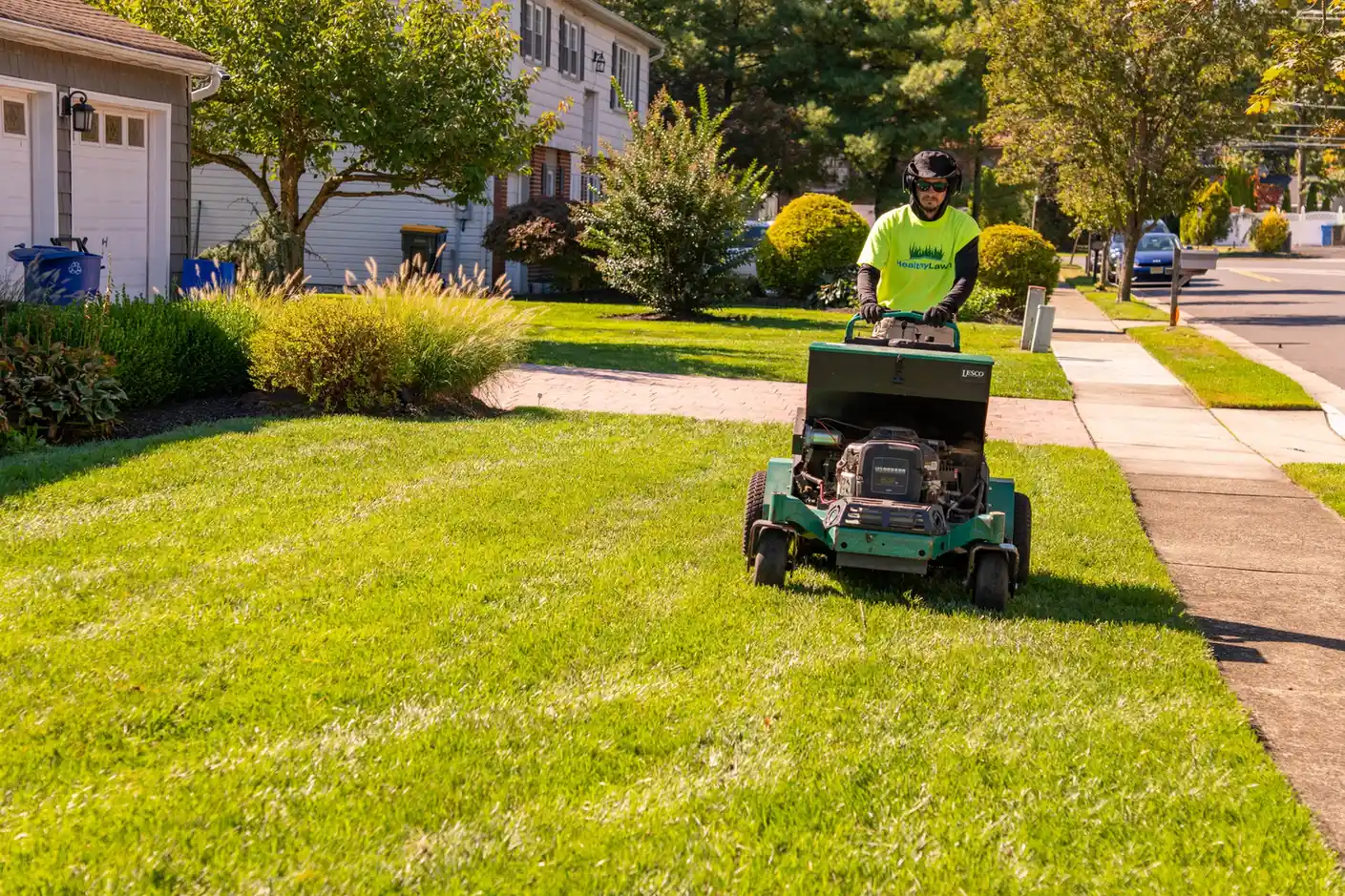 Healthy Lawn technician aerating a front lawn in New Jersey