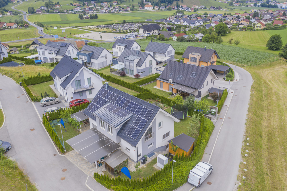 Einfamilienhaus mit Photovoltaikanlage auf dem Satteldach, Luftaufnahme einer Wohnsiedlung