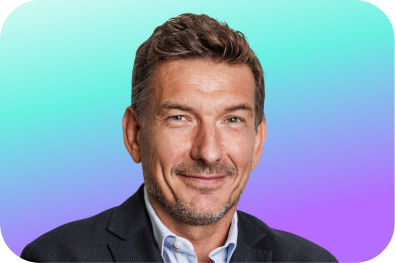 une photo de Cédric Robin, un des fondateurs de QANDLY en train de sourire avec un fond dégradé aux couleurs de QANDLY