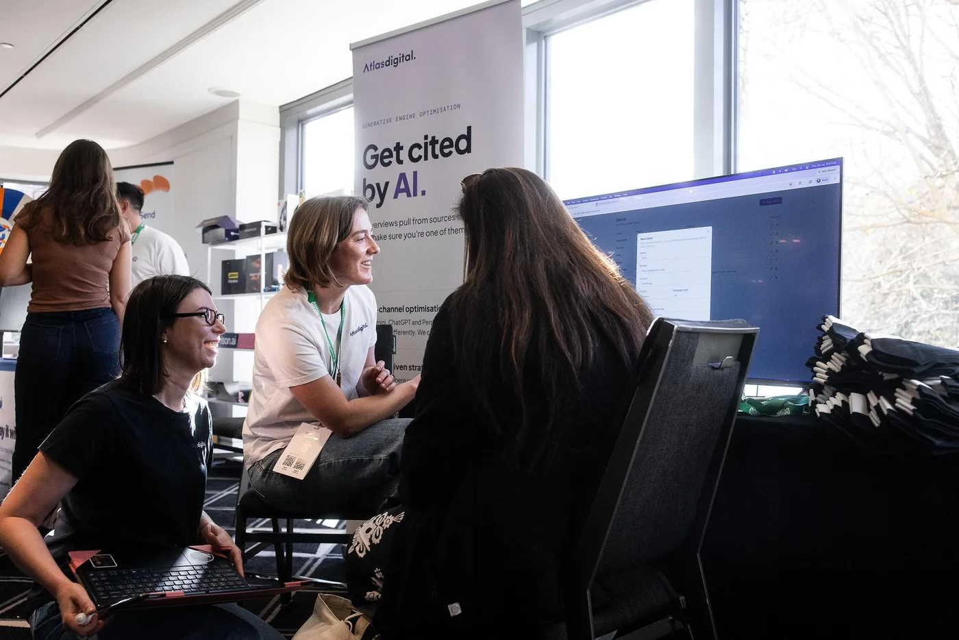 Atlas Digital team talking with visitors at a tech conference stand
