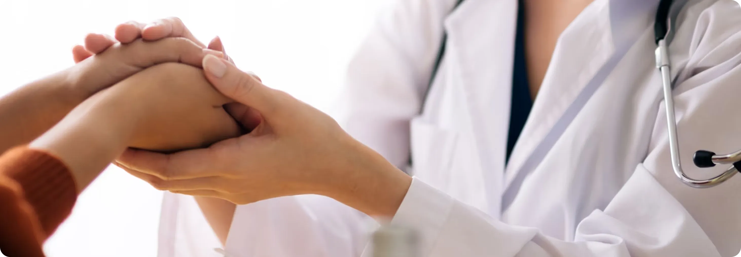 A woman holding the hand of a patient