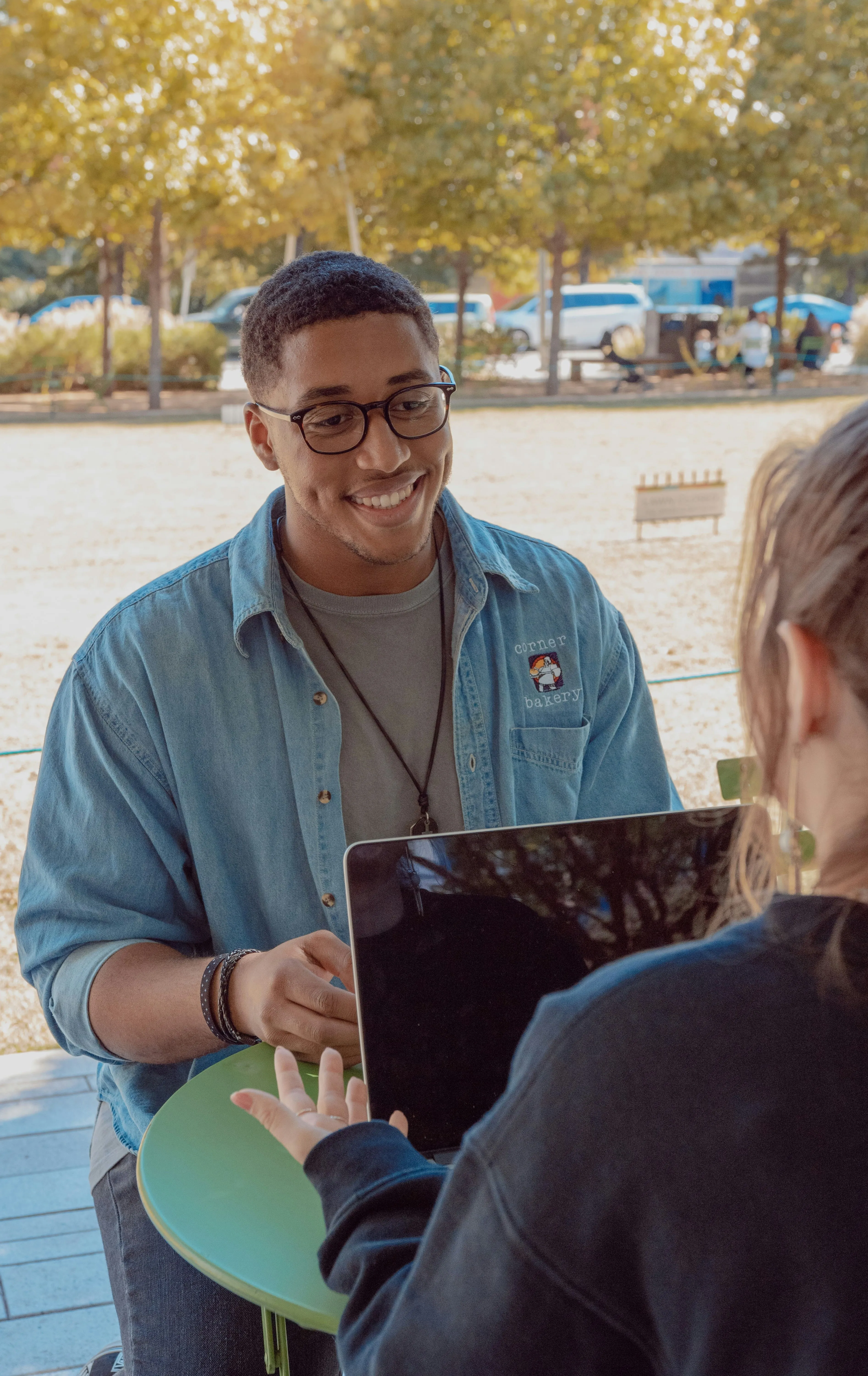 A man talking to a woman with a macbook