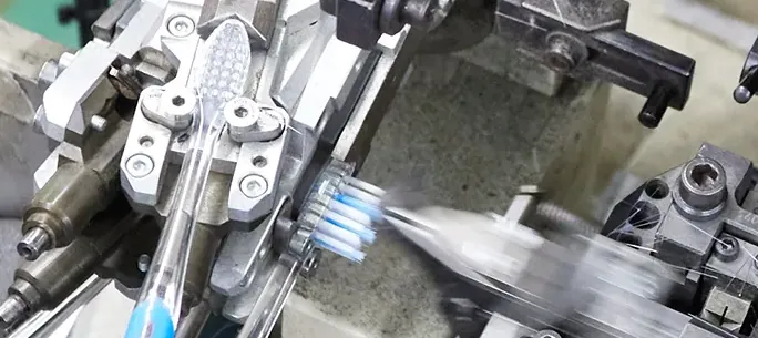 A toothbrush tufting machine on a factory line