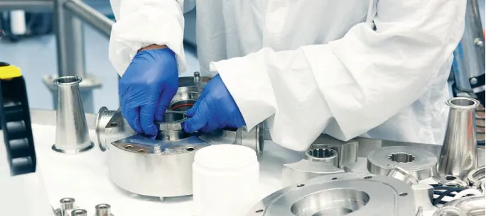 A lab technician in gloves testing a component