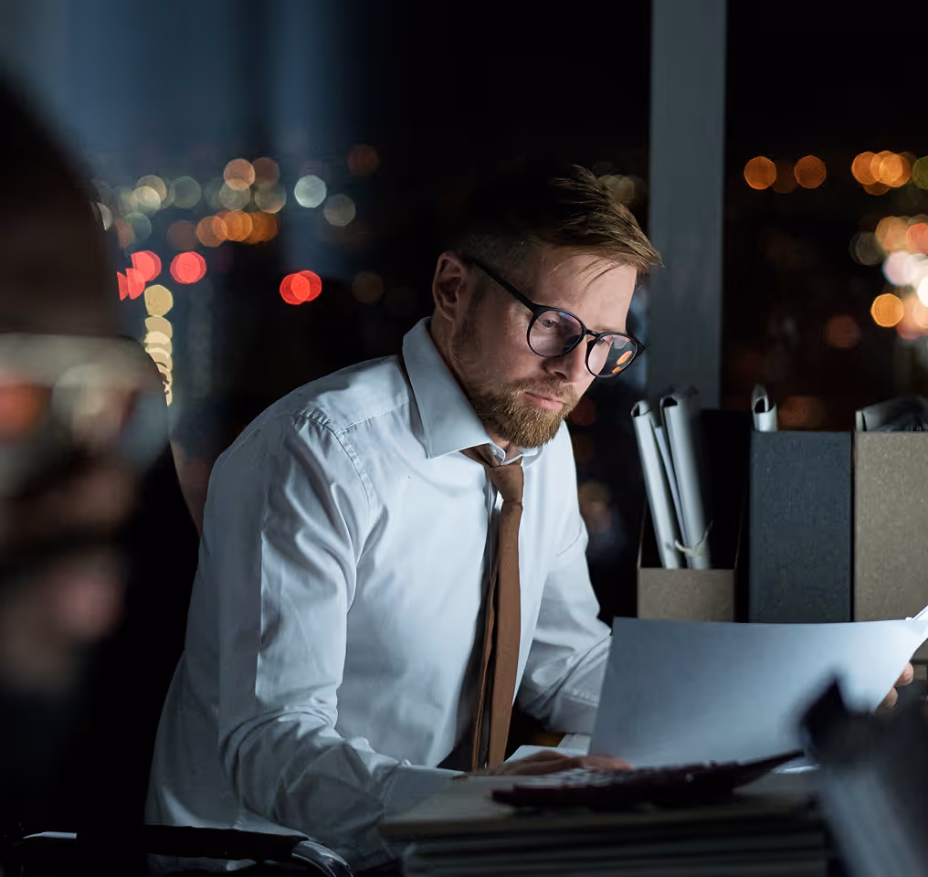 a man in a white shirt and tie working on a computer