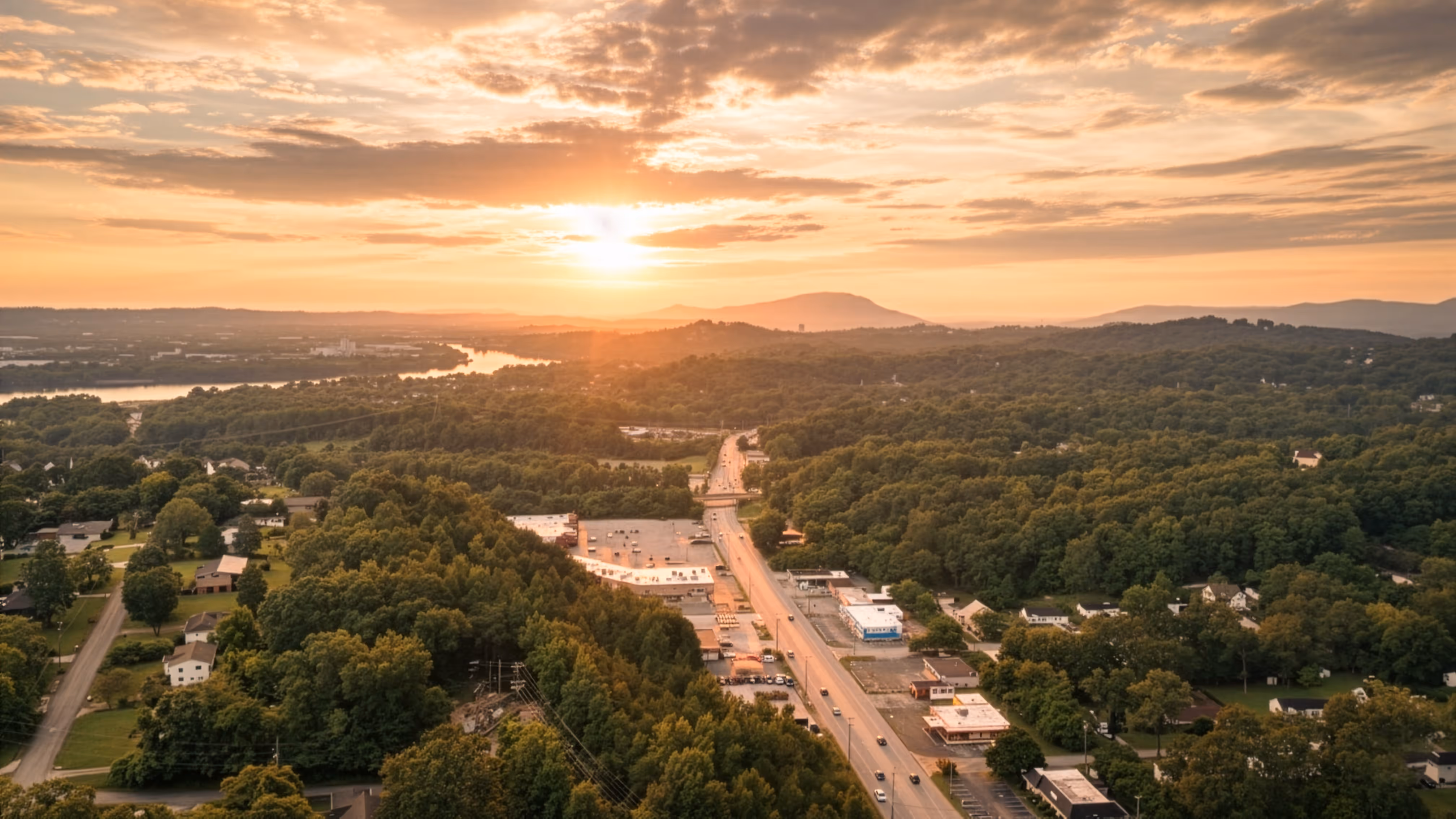 Sunset aerial photo over Hixson Pike in Hixson TN showing neighborhoods, trees, and views toward downtown Chattanooga and the Tennessee River.