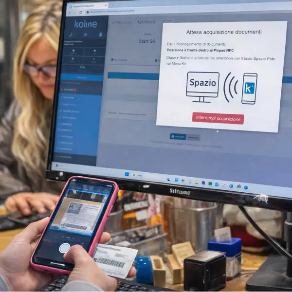 Operatrice consulta il catalogo prodotti di Kolme su monitor, con smartphone e prezzi visibili nella piattaforma digitale