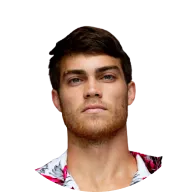 Nuori mies, jolla on tumma tukka ja parransänki, valkoinen paita, jossa on värikkäitä kuvioita.