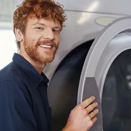Jeune homme ouvrant un sèche linge