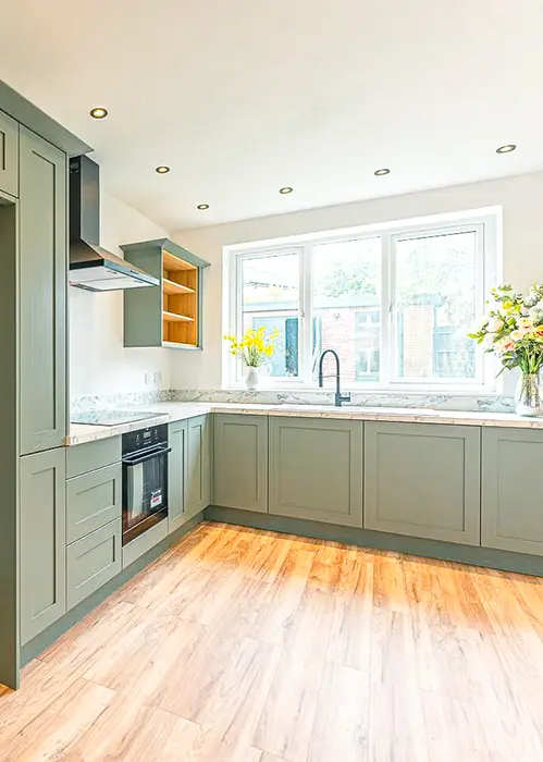 Kitchen with white worktops and green cabinets