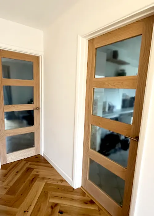 Modern oak doors with glass panels in hallway