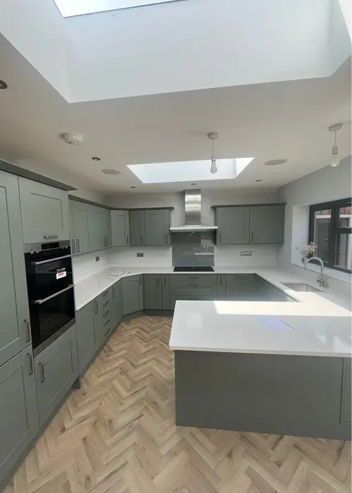 Sage green kitchen with white worktops